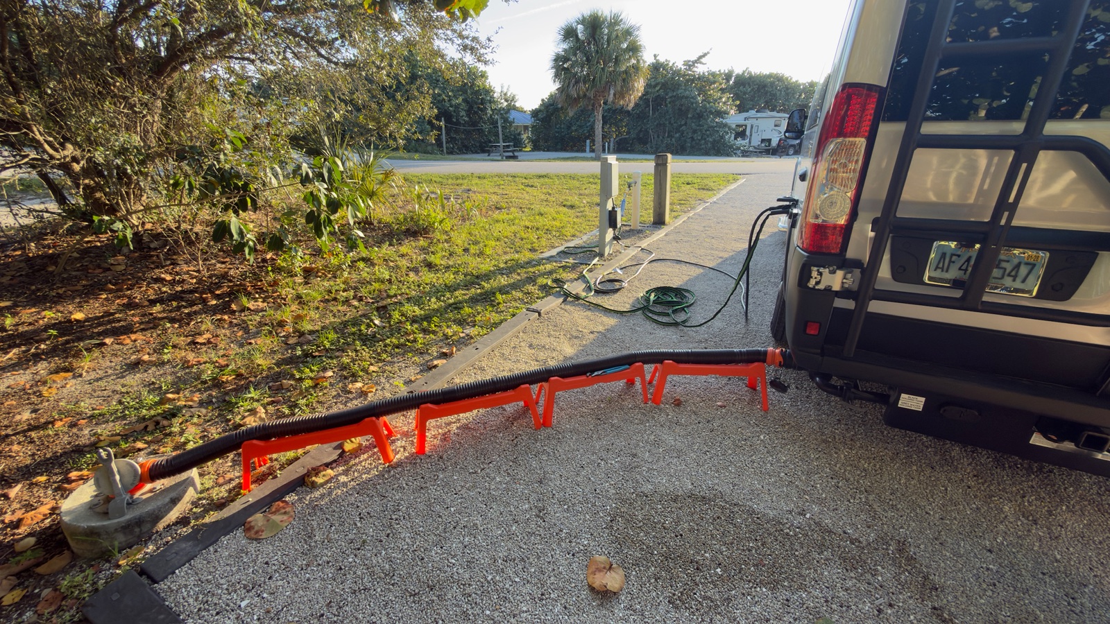 Hose and supports beside a camper van at a campsite